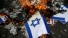 Seorang demonstran membakar mockup bendera Israel saat protes mengutuk keputusan Washington untuk mengakui Yerusalem sebagai ibu kota Israel, di luar kedutaan AS di Jakarta, 15 Desember 2017. (Foto: REUTERS/Beawiharta)