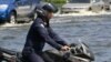 An Air Force officer rides his motorcycle through a flooded Paholyothin road near Don Muang airport in Bangkok, Thailand, October 25, 2011.