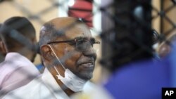 FILE - In this Sept. 15, 2020 file photo, Sudan's ousted president Omar al-Bashir sits at the defendant's cage during his trial a courthouse in Khartoum, Sudan, Sept. 15, 2020. 