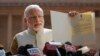 India's next Prime Minister and Hindu nationalist Bharatiya Janata Party (BJP) leader Narendra Modi displays the letter from the President inviting him to form the new government, outside the Presidential Palace in New Delhi, May 20, 2014. 