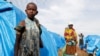 FILE - A girl who had part of her arm chopped off by militiamen when they attacked her village of Tchee, stands in a camp for internally displaced people in Bunia, Ituri province, Democratic Republic of Congo, April 12, 2018.
