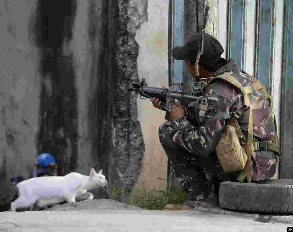 A government trooper takes his position while about 200 Muslim rebels, enraged by a broken peace deal with the Philippine government, held scores of hostages as human shields in a standoff with government forces for the second day at the southern port city of Zamboanga, in southern Philippines.