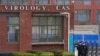 FILE - Security personnel gather near the entrance of the Wuhan Institute of Virology during a visit by the World Health Organization team in Wuhan, China, Feb. 3, 2021. 