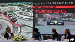 President and CEO of Formula 1 Chase Carey, left, Hanoi Mayor Nguyen Duc Chung, second from left and two other officials watch the Hanoi F1 circuit design on the screen in Hanoi, Vietnam, Wednesday, Nov. 7, 2018.