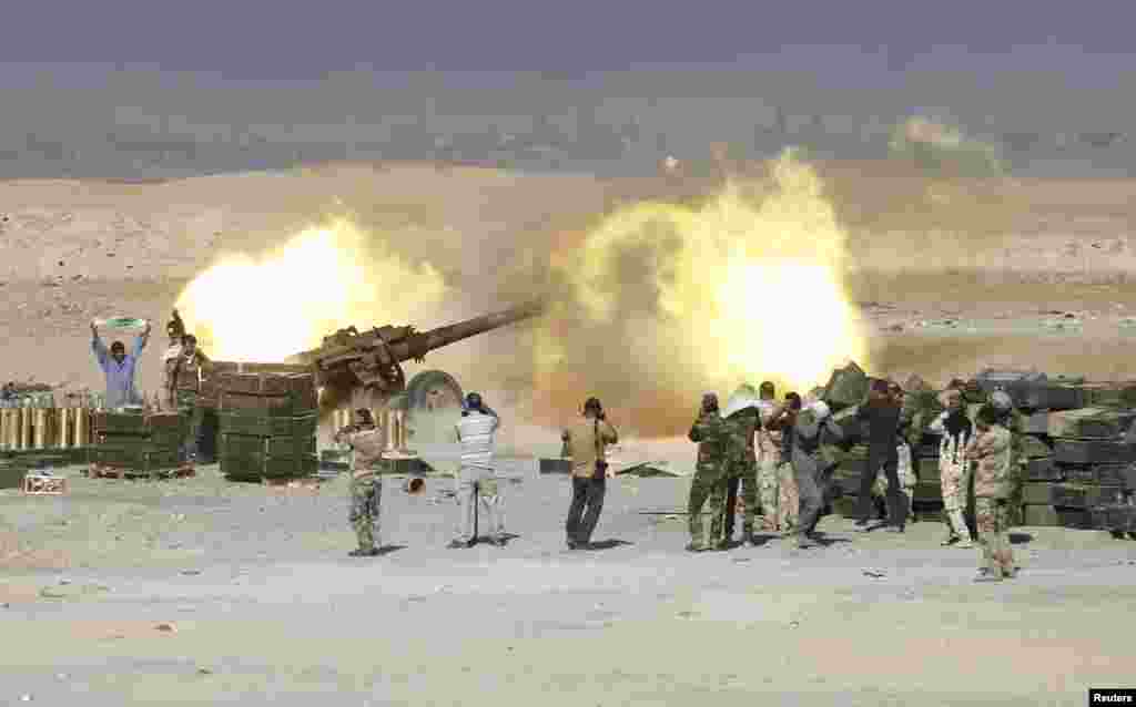 Shi&#39;ite fighters launch artillery toward Islamic State militants in al-Fatha, northeast of Baiji. Iraqi forces backed by Shi&#39;ite militia fighters say they have retaken a mountain palace complex of former President Saddam Hussein from Islamic State fighters, as government forces push ahead on a major offensive against the insurgents.