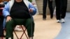 FILE - An overweight woman sits on a chair in Times Square, New York.