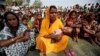 In this photo taken Monday, Feb. 10, 2014, migrant villagers gather to attend the awareness and service camp under National Rural Health Mission at a very remote Baralakhaiti village on the sandbars of River Brahmaputra, about 70 kilometers (43 miles) north of Gauhati, India.