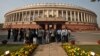 FILE - People stand in front of the Indian parliament building on the opening day of the winter session in New Delhi, Nov. 22, 2012. 