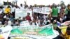FILE - Students and workers carry placards as they sit on the Lagos-Ikorodu highway to protest against the suspension of academic activities following a nationwide strike by lecturers in state-owned universities, Aug. 13, 2013 in Lagos. 