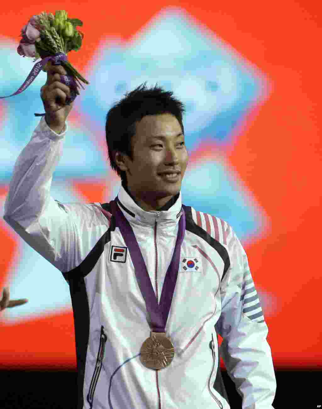 Bronze medalist Choi Byungchul of South Korea, waves to the crowd during the medals ceremony after the men&#39;s individual foil fencing competition at the 2012 Summer Olympics, July 31, 2012, in London. 