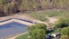 June Chappel’s home in Washington, Pennsylvania, is surrounded by gas drilling: a waste containment pond behind her and gas tanks to the side.
