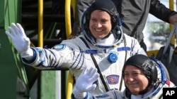FILE - U.S. astronaut Jack Fischer, above, and Russian cosmonaut Fyodor Yurchikhin, crew members of the mission to the International Space Station, wave near the rocket prior launch at the Russian-leased Baikonur cosmodrome, Kazakhstan, April 20, 2017. 