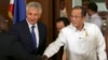Philippine President Benigno Aquino III, right, shakes hands beside U.S. Defense Secretary Chuck Hagel, center, during his visit at the Malacanang Presidential Palace in Manila, Philippines, Aug. 30, 2013.