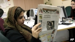 FILE - Iranian journalist Elahe Khosravi, reads Iranian daily newspaper Hamshahri, in Tehran, Iran on Tuesday, Feb. 7, 2006. The prominent Iranian newspaper said it would hold a competition for cartoons on the Holocaust to test whether the West extends the principle of freedom of expression to the Nazi genocide as it did to the caricatures of the Prophet Muhammad. 