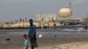 FILE - A man stands with his son on the beach near the Kudankulam nuclear power project in the southern Indian state of Tamil Nadu. 