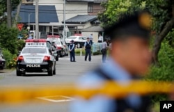 Police officers stand guard at a crossroad near the Tsukui Yamayuri-en, a facility for the handicapped, where a number of people were killed and dozens injured in a knife attack in Sagamihara, outside of Tokyo, Japan, July 26, 2016.