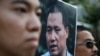 FILE - Anti-Beijing protesters, with a picture of human rights lawyer Pu Zhiqiang, protest outside the Chinese liaison office to demand Pu's release, in Hong Kong, Tuesday, Dec. 15, 2015.