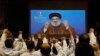 FILE - Hezbollah scouts raise their fists and cheer as they listen to a speech of Hezbollah leader Hassan Nasrallah, via video link, during a rally in southern Beirut, Lebanon, April 22, 2019. 