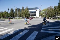 FILE - People ride colorful bikes on the Google campus in Mountain View, California, Oct. 28, 2014.