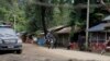 Local residents ride a motorcycle past a police checkpoint in Myanmar's border town of Maungdaw, Rakhine State, Oct. 13, 2016.