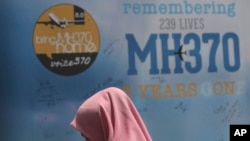 Seorang prempuan berdiri di depan pesan duka cita dalam Hari Peringatan MH 370, 3 Maret 2019. Pesawat itu hilang pada 8 Maret 2014 dalam penerbangan ke Beijing dari Kuala Lumpur dengan membawa lebih dari 200 penumpang dan kru. (Foto: Vincent Thian/AP Photo)