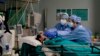 FILE - Medical staff tend to a patient in the emergency COVID-19 ward at the San Carlo Hospital in Milan, Italy, April 16, 2020.