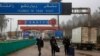 People carrying their belongings cross into to Syria from Turkey through the Kassab crossing on Dec. 27, 2024. 