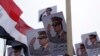 FILE - Posters of Army Chief General Abdel Fattah al-Sisi are seen as supporters of the army protest against ousted Islamist President Mohamed Morsi.