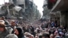 FILE - This picture taken on Jan. 31, 2014, and released by the UNRWA, shows residents of the besieged Palestinian camp of Yarmouk, queuing to receive food supplies, in Damascus, Syria. 