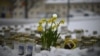 Candles and flowers are placed in the snow in front of the Viertola School to pay tribute to victims in Vantaa, in the north of the Finnish capital, Helsinki, on April 3, 2024. The day before, a 12-year-old allegedly opened fire inside the school, killing a classmate.