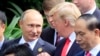 Le président russe Vladimir Poutine, à gauche, et le président américain Donald Trump discutent lors de la séance de photos de famille en marge du sommet de la Coopération économique Asie-Pacifique (APEC) à Danang, Vietnam, 11 novembre 2017. 