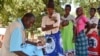 A health worker records information from patient's health passport in Balaka district in southern Malawi. Feared to be carriers of the coronavirus, some medical workers in Malawi have been increasingly shunned. (Lameck Masina/VOA)