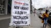 Une femme passe devant un panneau affichant un titre en une d'un quotidien sud-africain pendant l'épidémie de coronavirus à Johannesburg, en Afrique du Sud, le 8 février 2021.
