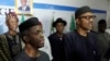 Nigerian former Gen. Muhammadu Buhari, right, along with his deputy, Yemi Osibnajo, sings the national anthem after speaking to journalists in Abuja, Nigeria, April 1, 2015. 