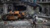 A boy rides his bike past destroyed cars and houses in a neighborhood recently liberated by Iraqi security forces, on the western side of Mosul, Iraq, Sunday, March 19, 2017.