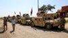 Military vehicles of Iraqi security forces and Shi'ite fighters are seen as they gather at Udhaim dam, north of Baghdad, March 1, 2015. 