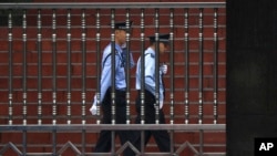 FILE - Chinese policemen are seen on patrol in southwest China's Sichuan province, Sept. 24, 2012. A police report on the death of a 14-year-old student whose body was found outside his dormitory at Taifu Middle School in Luzhou, Sichuan province, has raised questions about the investigation.