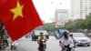 People wearing face masks to help curb the spread of the coronavirus ride mopeds in Hanoi, Vietnam on Aug. 6, 2020.