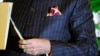 A close-up view of Indian Prime Minister Narenda Modi's dark pinstripe suit, repeatedly embroidered with the words "Narendra Damodardas Modi", as he talks to U.S. President Barack Obama while walking through the garden at Hyderabad House in New Delhi, Ja