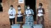 Electoral officials wearing face masks to protect against the coronavirus, stand by ballot boxes before voters cast their votes in a presidential election, in Giheta, Gitega province, Burundi, May 20, 2020. 