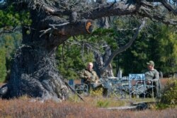 In this undated photo released by Russian Presidential Press Service, Russian President Vladimir Putin, left, and Russian Defense Minister Sergei Shoigu during a holiday in southern Siberia's mountains during a break from state affairs.