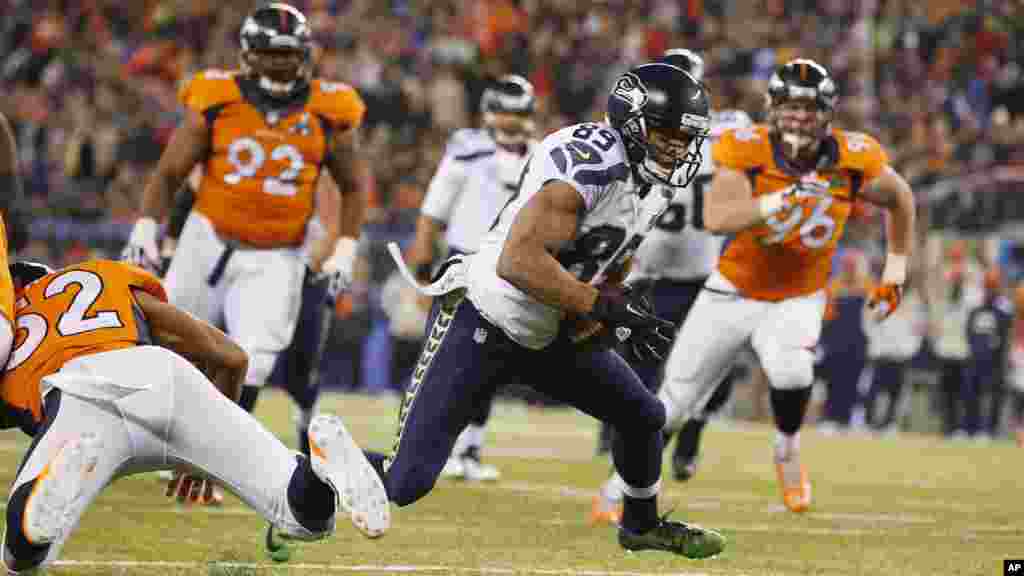 Seattle Seahawks' Doug Baldwin (89) runs from Denver Broncos' Wesley Woodyard (52) during a 10-yard touchdown reception in the second half of the NFL Super Bowl XLVIII football game.