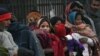 FILE - Indian homeless people wait for free food outside a temple, in New Delhi, India, Jan. 1, 2013.