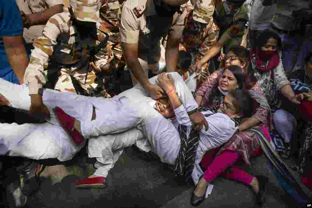 India&#39;s opposition Congress party supporters protesting against gang rape and killing of a woman in Uttar Pradesh&rsquo;s Hathras district hold onto each other as policemen try to detain them in New Delhi.