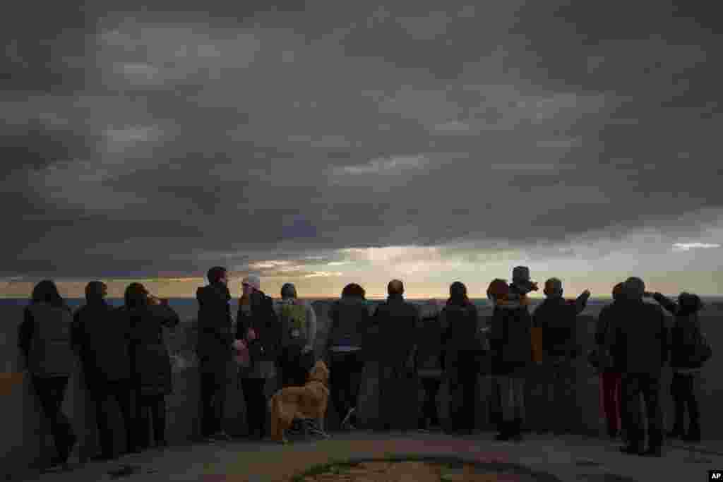 Visitors watch the city on top of a mountain that served as a strategic site for the defense of Barcelona during the Spanish Civil War.&nbsp;The hill known as the Turo de la Rovira, offers a 360 degree view of the city and it contains the remains of an anti-aircraft battery that helped to defend Barcelona from air attacks during the Civil War.
