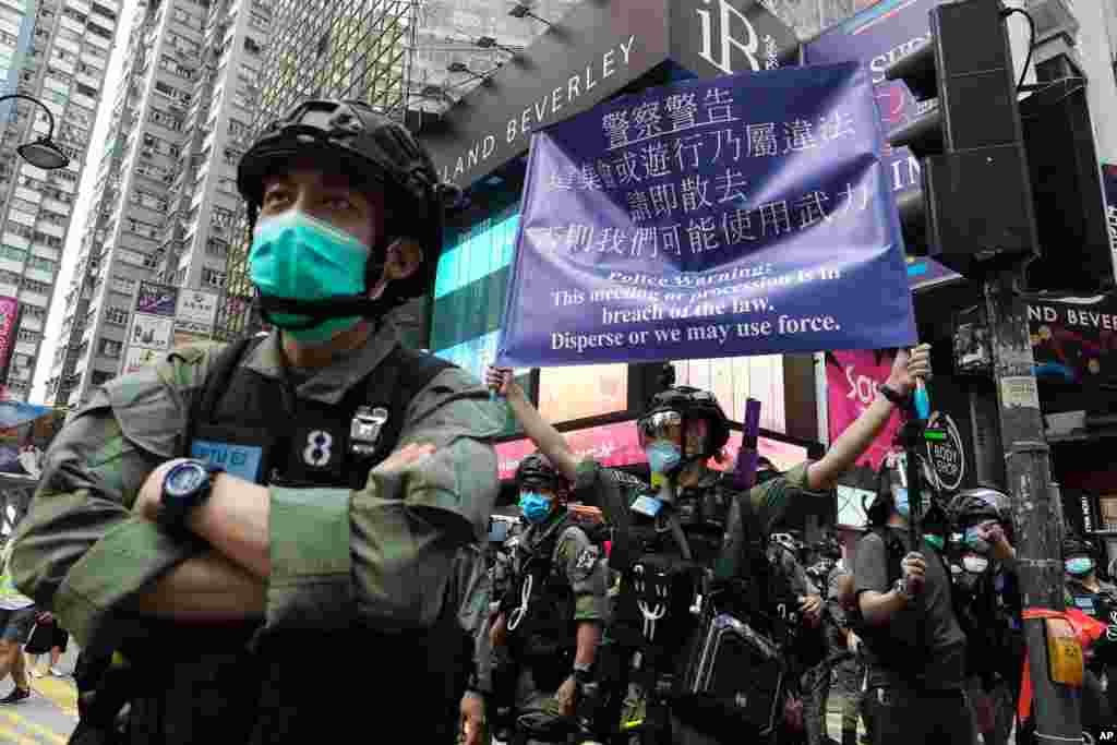 A police officer displays a warning banner on China's National Day in Causeway Bay, Hong Kong.