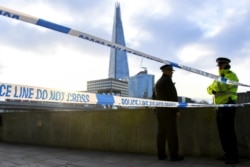 Police officers patrol the scene in central London, Dec. 1, 2019, after a knife attack on London Bridge.