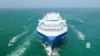 FILE - The Galaxy Leader cargo ship is escorted by Houthi boats in the Red Sea in this photo released Nov. 20, 2023. Because of Houthi attacks on Red Sea vessels, some shippers are starting to carry cargo by trucks driven through Saudi Arabia. (Houthi Military Media via Reuters) 