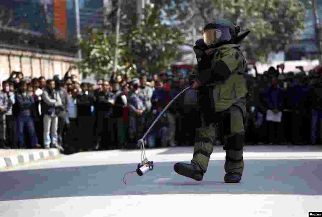 A member of the army&#39;s bomb disposal team carries a suspicious object after a bomb scare outside the Singha Durbar office complex that houses the Prime Minister&#39;s office and other ministries, in Kathmandu, Nepal.