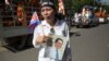 រូបឯកសារ៖​ ស្ត្រី​ម្នាក់​កាន់​រូបភាព​លោក កែម ឡី ខណៈ​ពេល​ប្រជា​ពលរដ្ឋ​រាប់​ម៉ឺន​នាក់​ចូលរួម​ជូន​ដំណើរ​លោក​ កែម ឡី​ នៅ​ថ្ងៃ​អាទិត្យ​ ទី​២៤ ខែកក្កដា​ ឆ្នាំ២០១៦​នេះ។​